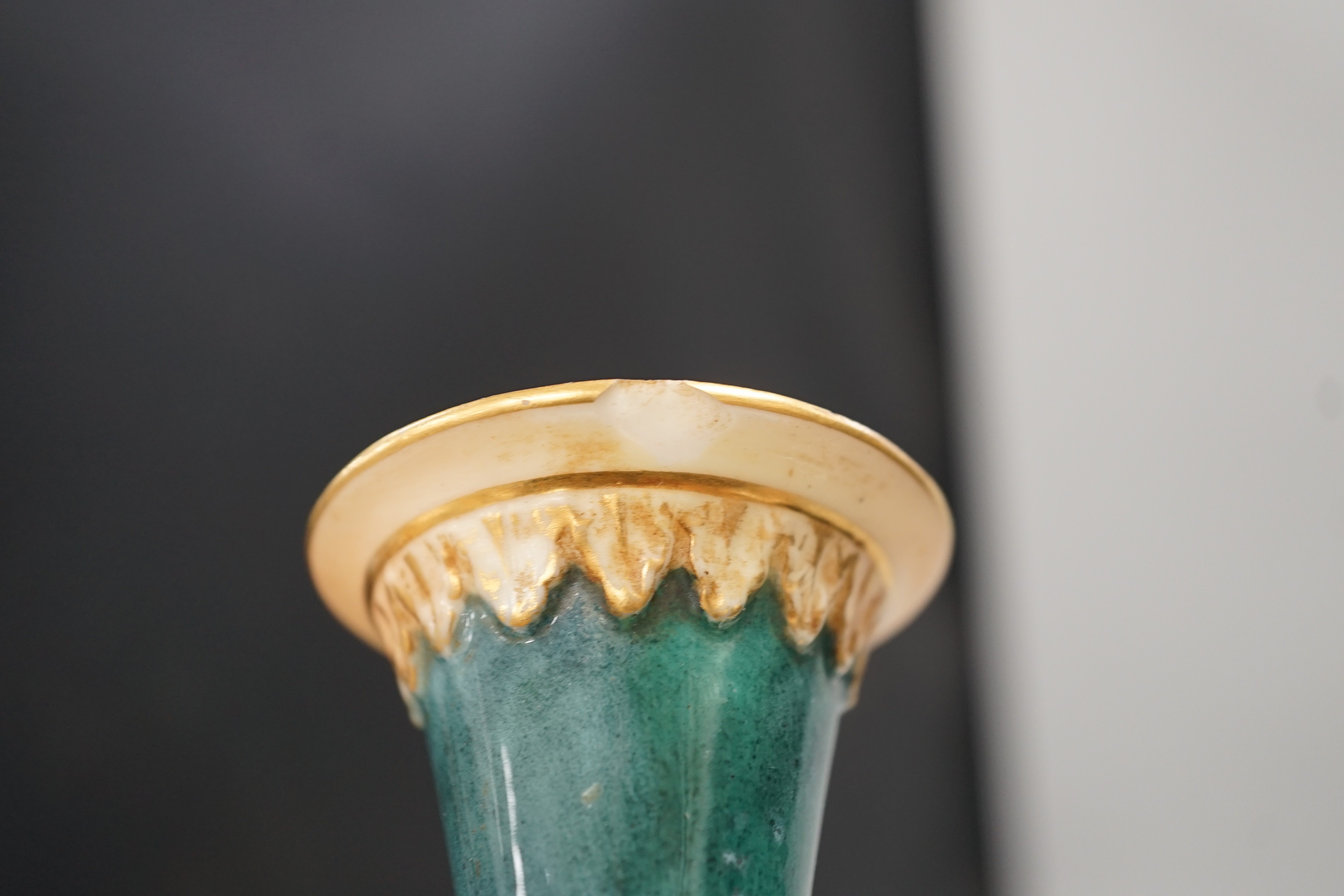 Three Royal Worcester pedestal vases, each of ovoid form and supported on circular pedestal feet, two are decorated with flowers and thistles, the other depicting a rural landscape within a gilt foliate C scroll cartouch